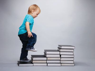 Niño subiendo escalera de libros